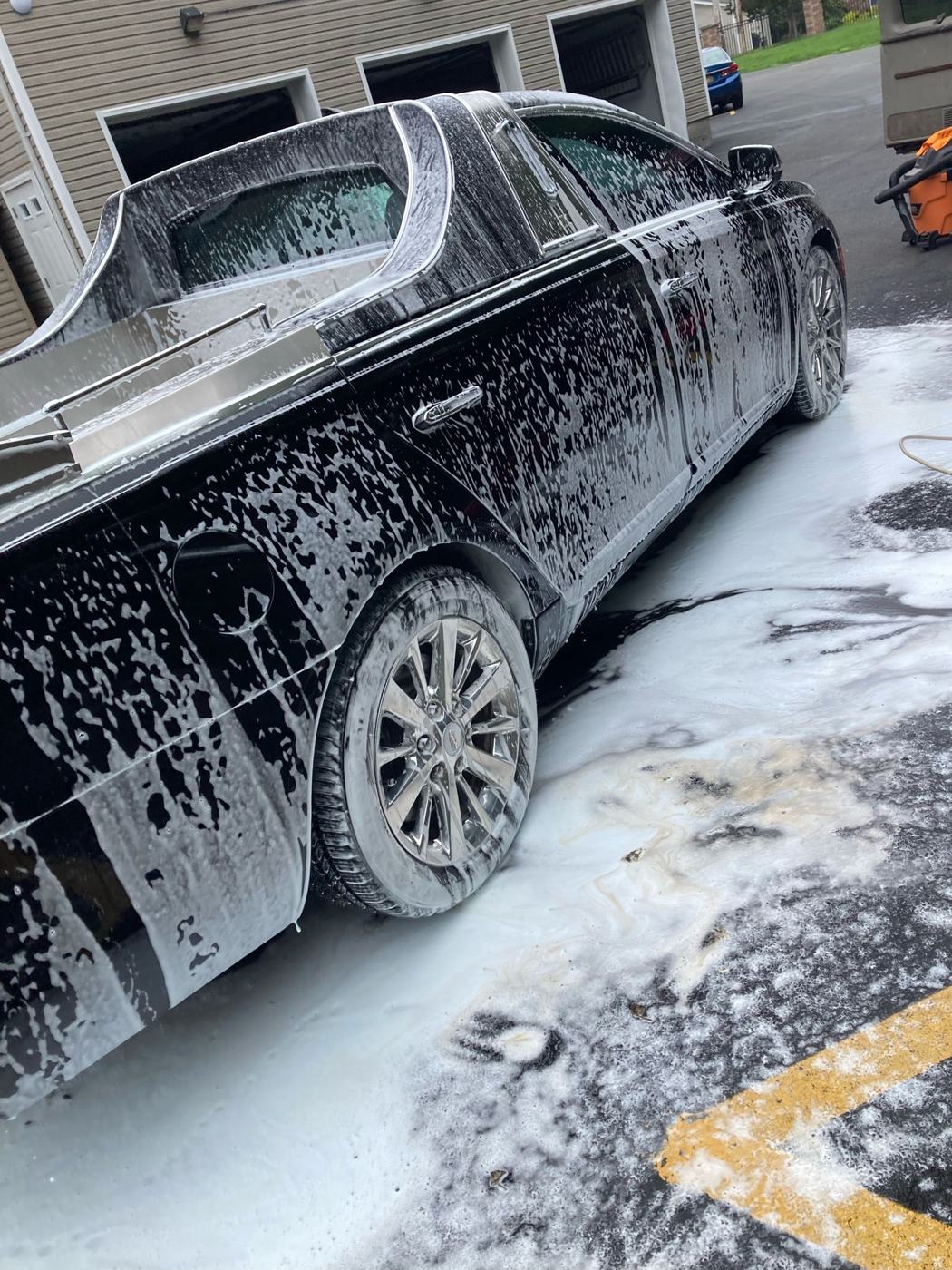 Luxury sedan covered in foam during hand wash